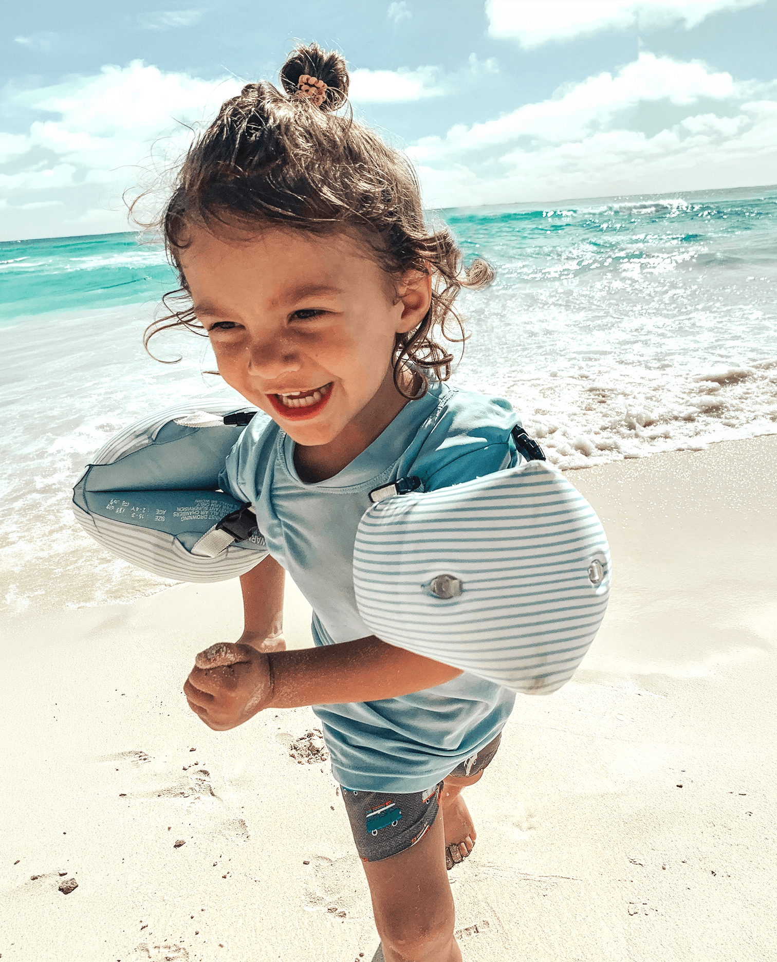 Child wearing Otter Wings water wings on a beach in Mexico