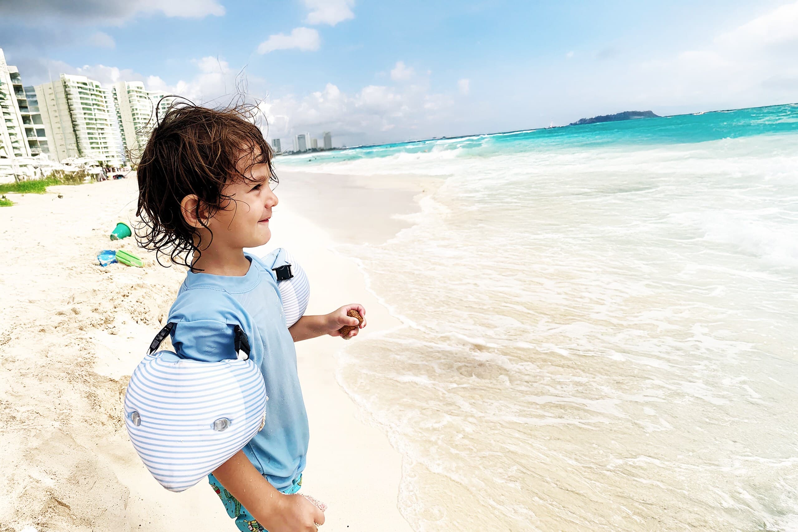 Child wearing Otter Wings on a beach